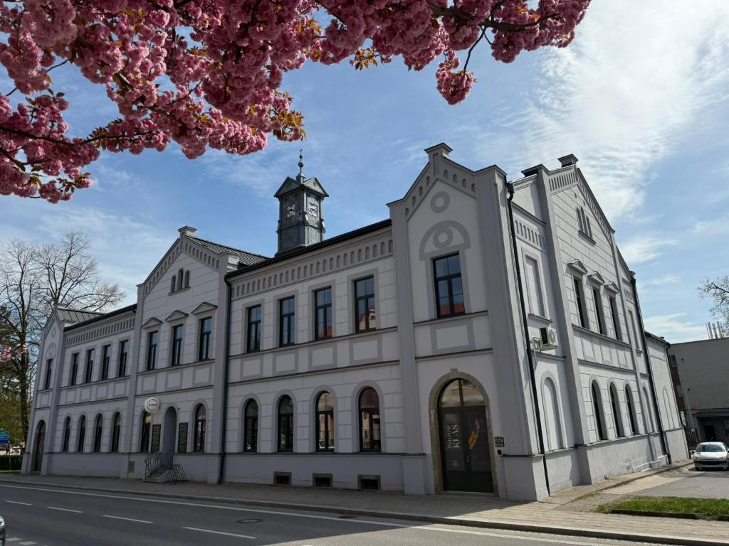 a large white building with a clock tower at Penzion Klas in Měřín