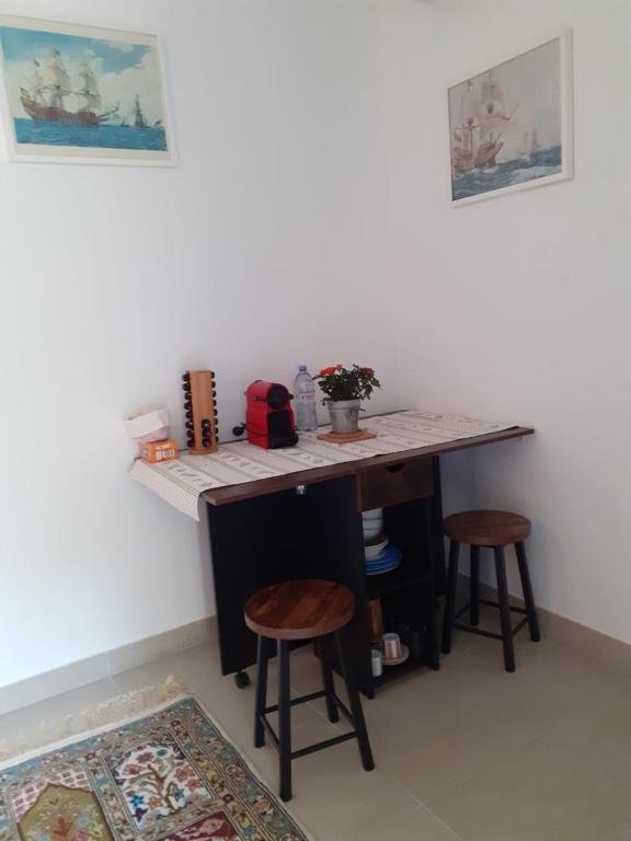 a room with a desk with two stools and a table at Les Jasmins in Montaud
