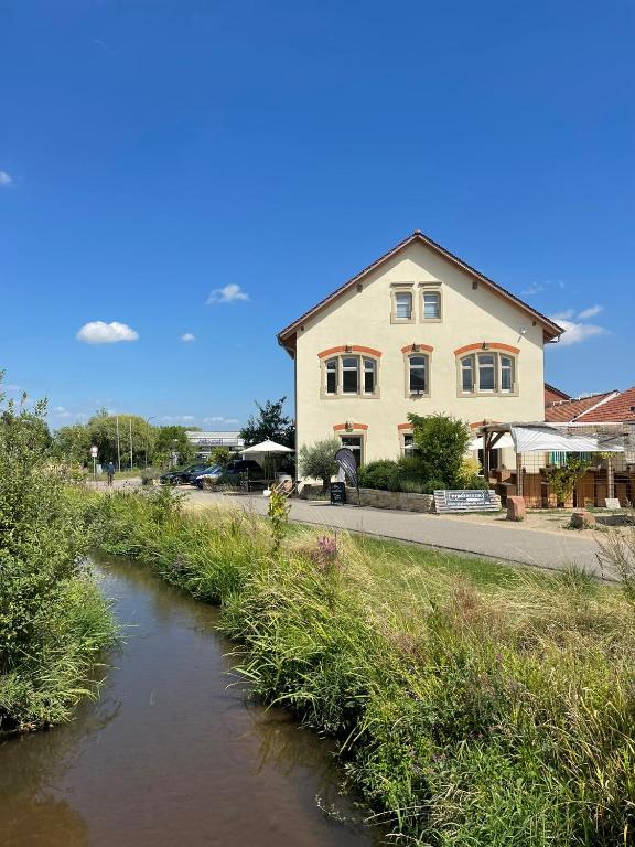 a house and a river in front of a building at Schwarzfabrik in Bad Dürkheim