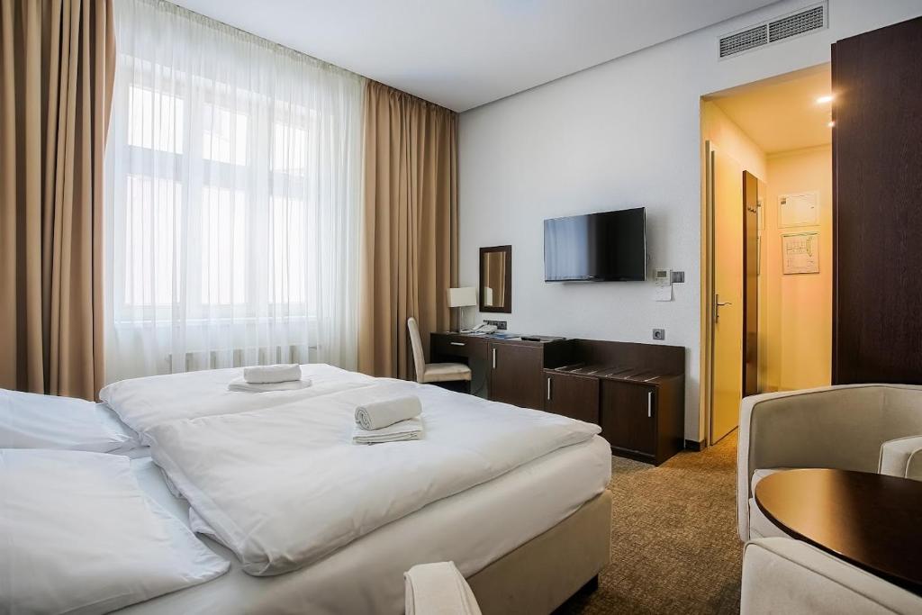 a hotel room with a large bed and a desk at Ensana Pro Patria in Piešťany