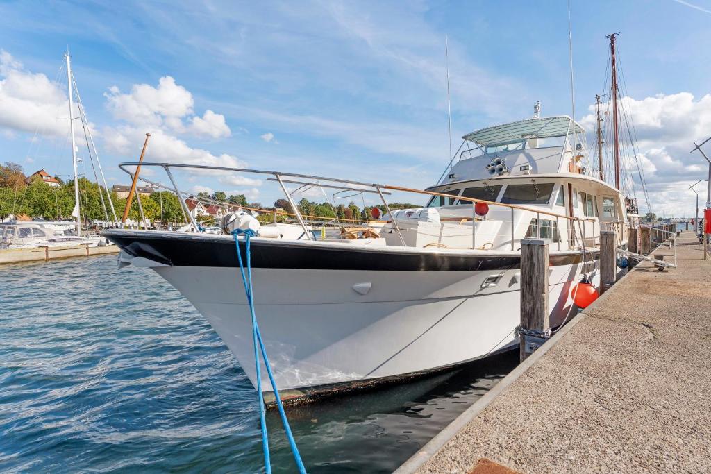 a white boat docked at a dock in the water at Klassische Motoryacht Ocean Motion in Flensburg