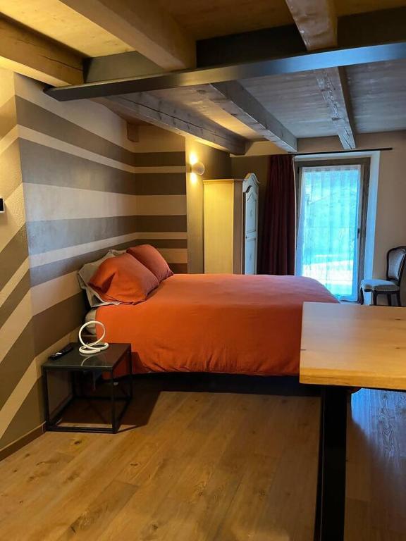 a bedroom with a bed with a striped wall at La Breila Morgex in Morgex