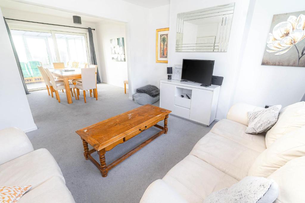 a living room with a couch and a table at 3-bedroom pet friendly home with off road parking in Swansea