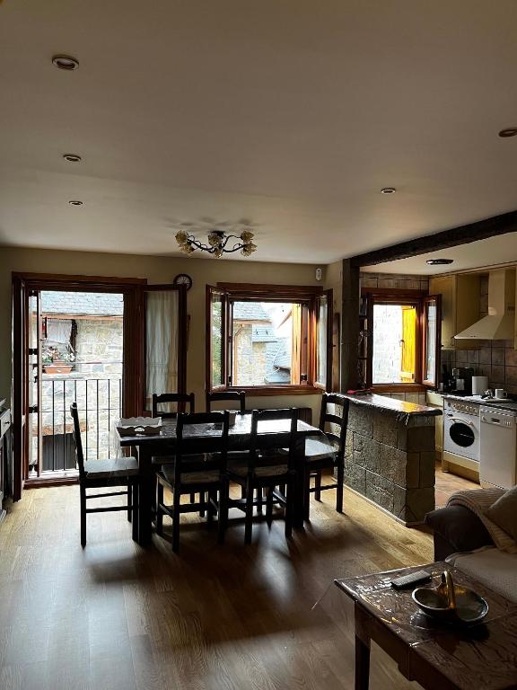 a living room with a dining table and a kitchen at Ibón de la Sierra in El Pueyo de Jaca