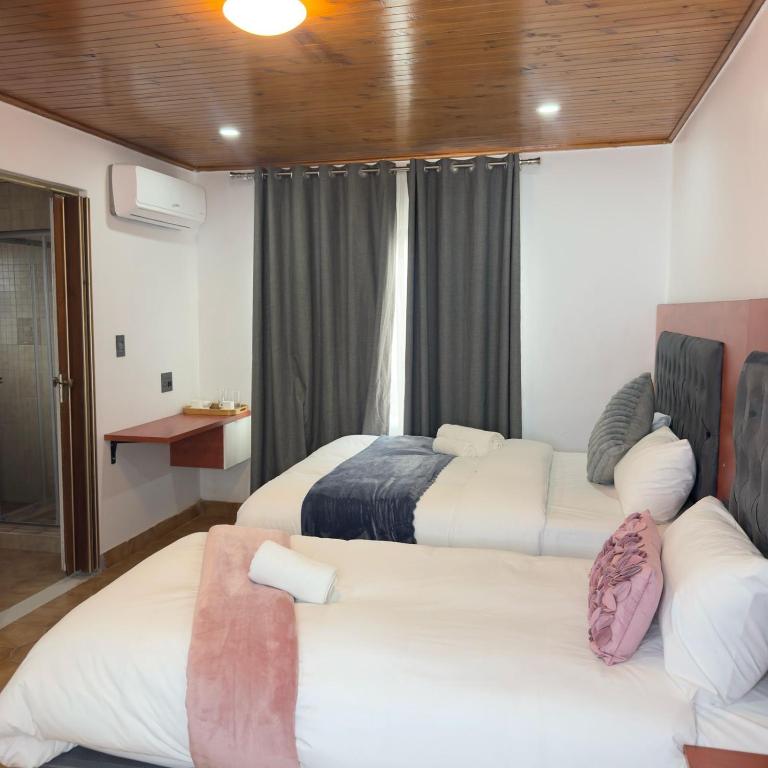 a room with two beds and a couch in it at Cozy Villa Lodge in Edenvale