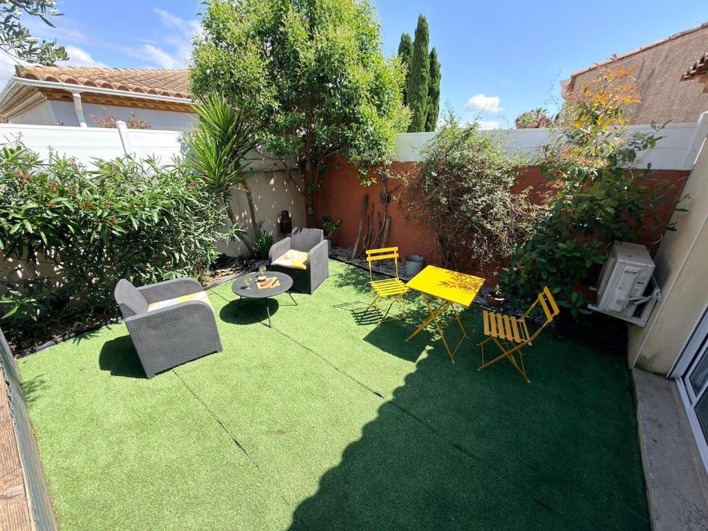 a small backyard with chairs and a table and chairs at Studio avec jardin privé et parking gratuit in Mudaison