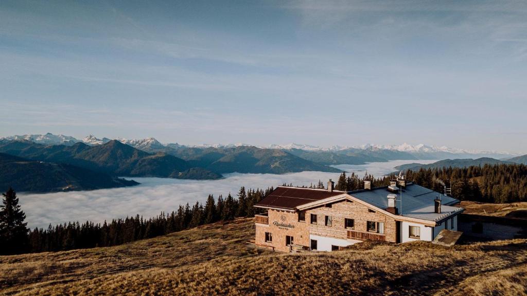 a house on top of a hill with a view of the mountains at Radstädter Hütte am Rossbrand in Radstadt