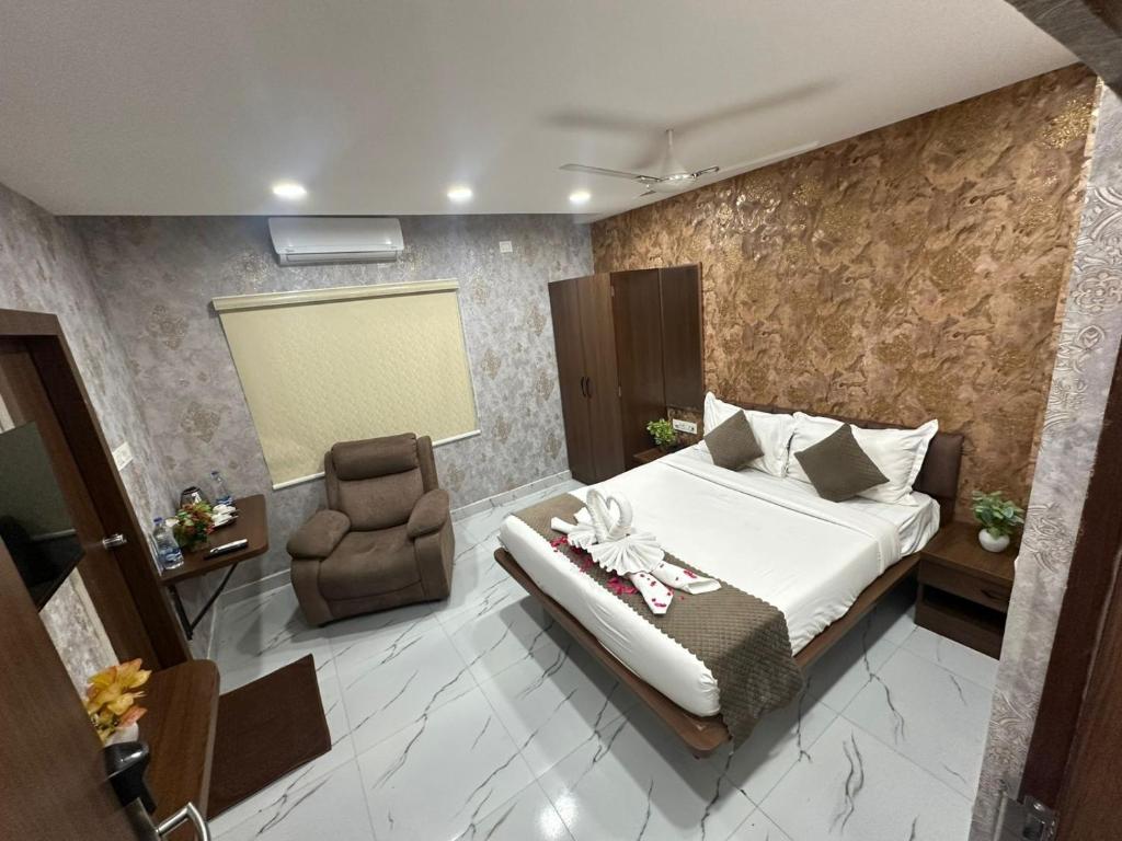 a hotel room with a bed and a chair at Hotel Apex Inn Hyderabad Airport in Hyderabad
