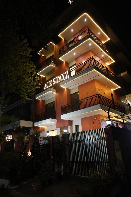 a large building with a sign on it at night at Ace Stayz - Boutique Hotel Near DLF Mall Sector 45, Noida in Noida