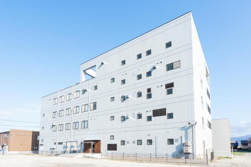 a large white building with many windows at たびのホテル佐渡Annex in Sado