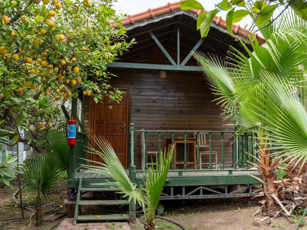 a wooden house with a green bench in front of it at Atıcı 2 Hotel in Adrasan