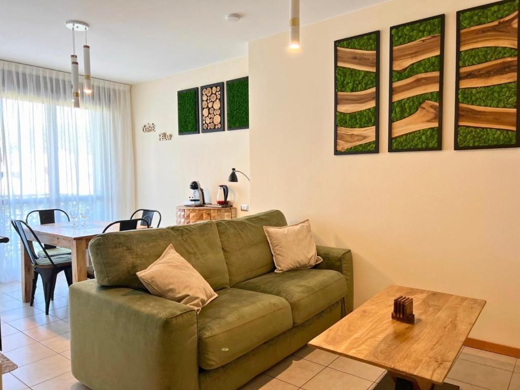 a living room with a green couch and a table at Appartamento Mango in Cavallino-Treporti