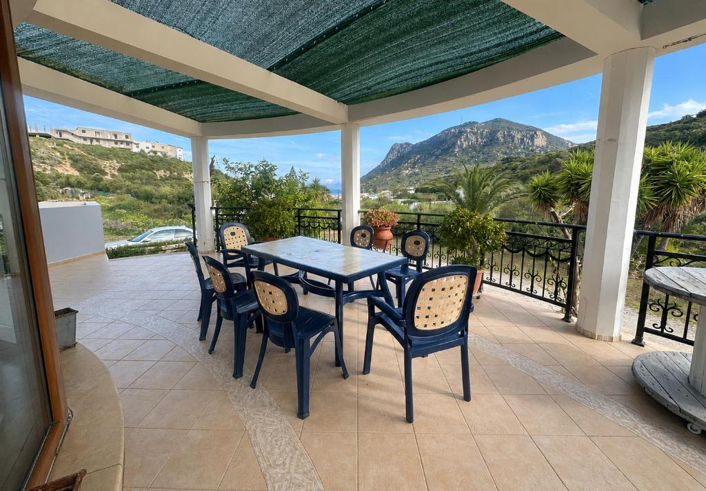 a table and chairs on a patio with a view at Peaceful Retreat - Kefalos Stay with Patio views & gym in Kefalos