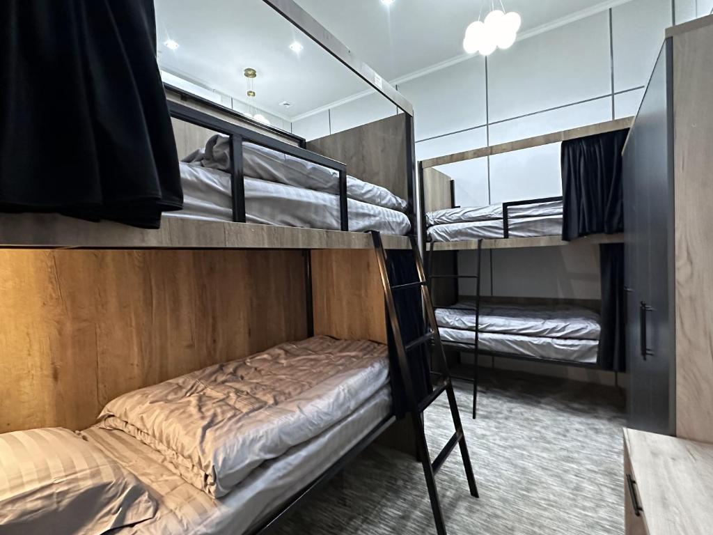 two bunk beds in a room with a mirror at Aslan Hostel in Samarkand