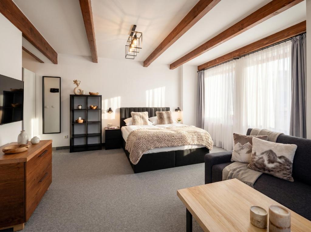 a living room with a bed and a couch at Golden Apartments - Villa Taternik - Tatry View in Zakopane