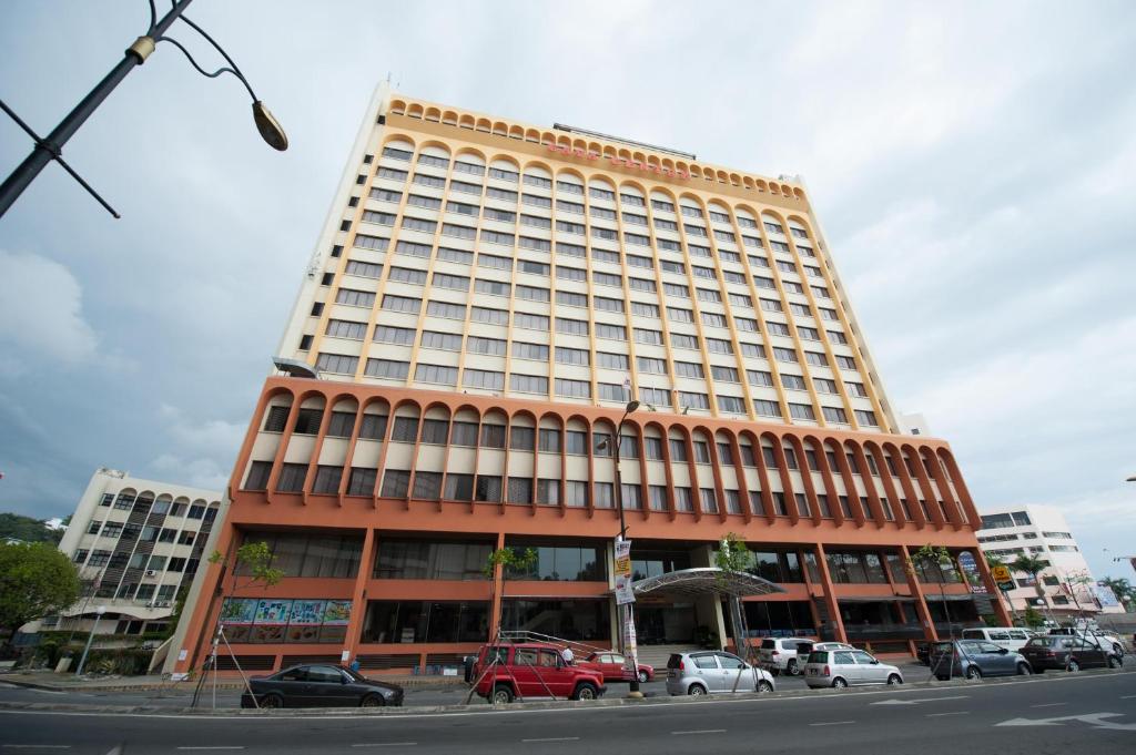 a large building with cars parked in front of it at Gaya Centre Hotel in Kota Kinabalu