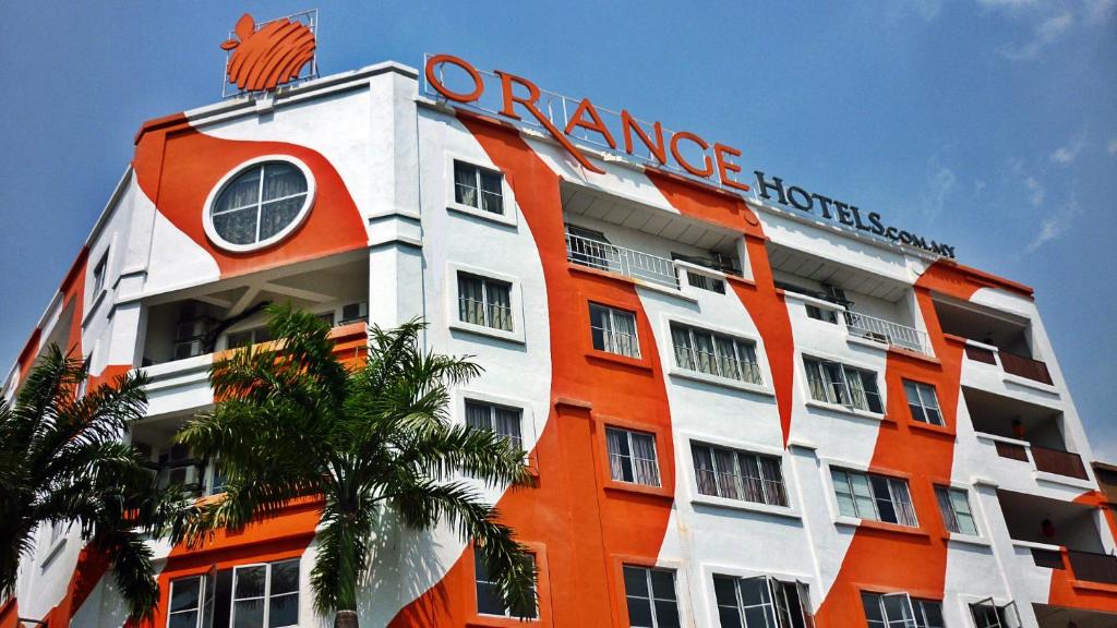 um edifício laranja e branco com um sinal em Orange Hotel Kota Kemuning @ Shah Alam em Shah Alam