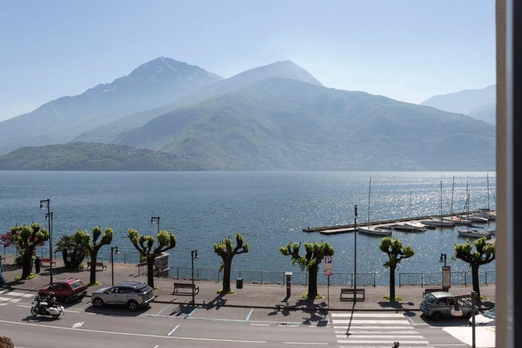 a parking lot next to a body of water with mountains at Piazzetta Lake View by Halldis in Dongo
