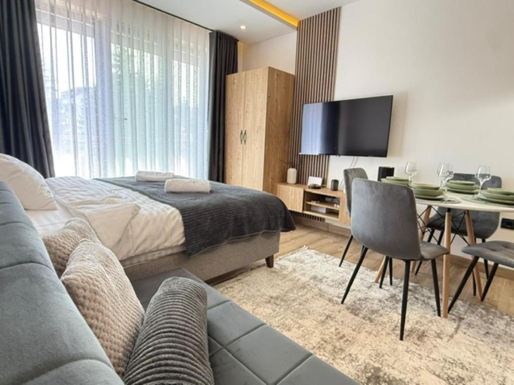 a bedroom with a bed and a table and a tv at Misho Hills Retreat in Kopaonik