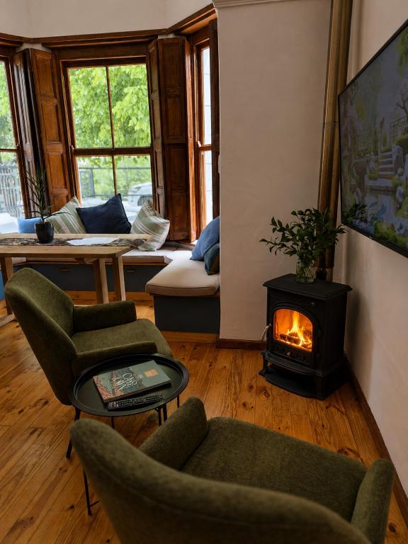 a living room with a fireplace and chairs and a couch at Under the Maple in Rawsonville