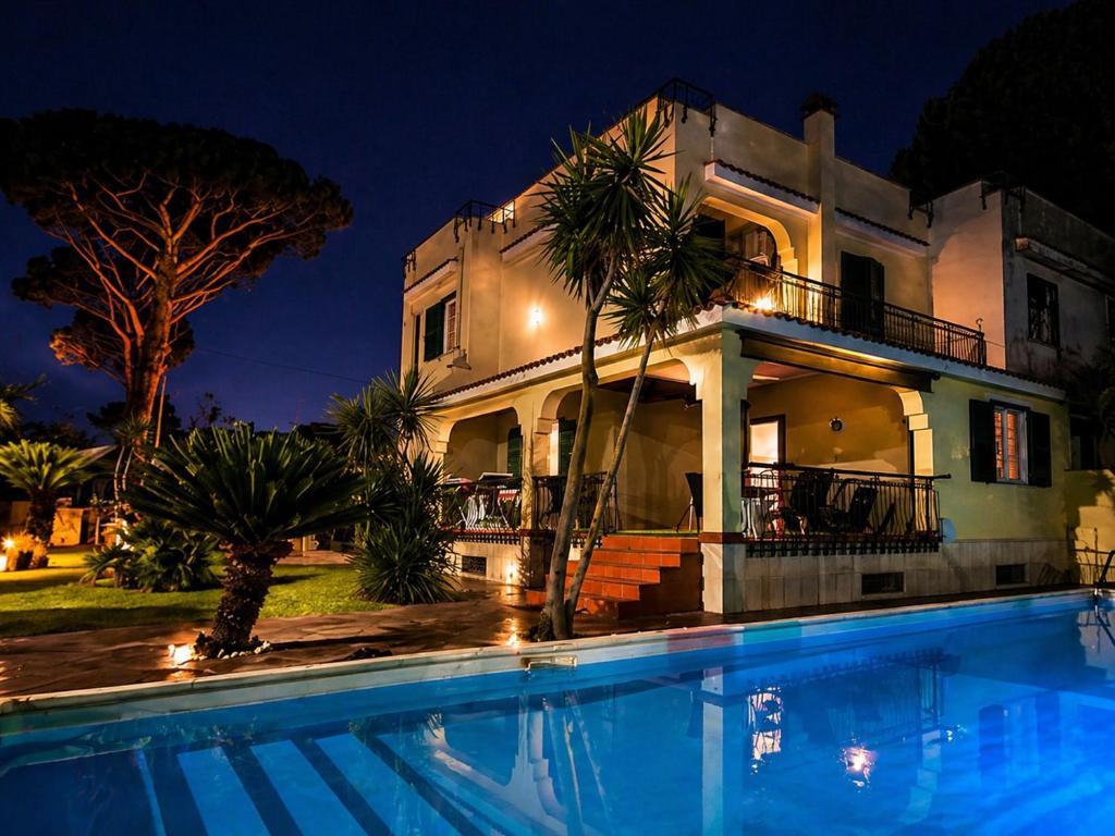 a house with a swimming pool in front of it at Villa SOLE di AMORE - POOL PRIVATE LARGE 100 M 2 - Beach 950m -Center 500 m - ROME & AIRPORT 39 km in Anzio