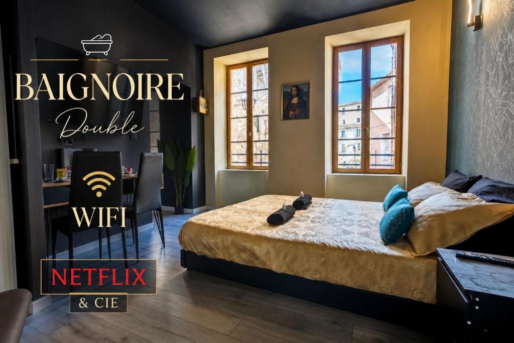 a bedroom with a bed and a table and windows at Baignoire Centre Ville Narbonne in Narbonne