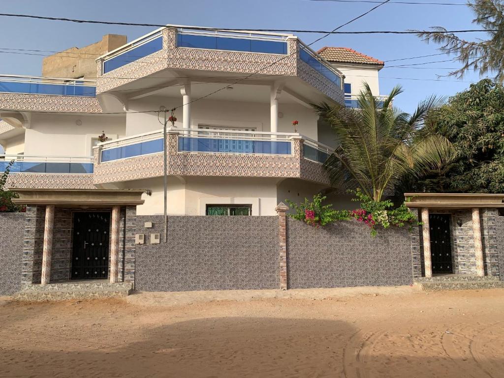 a building with a fence in front of it at Le Wallo - Residence Sebi in Sébikhoutane