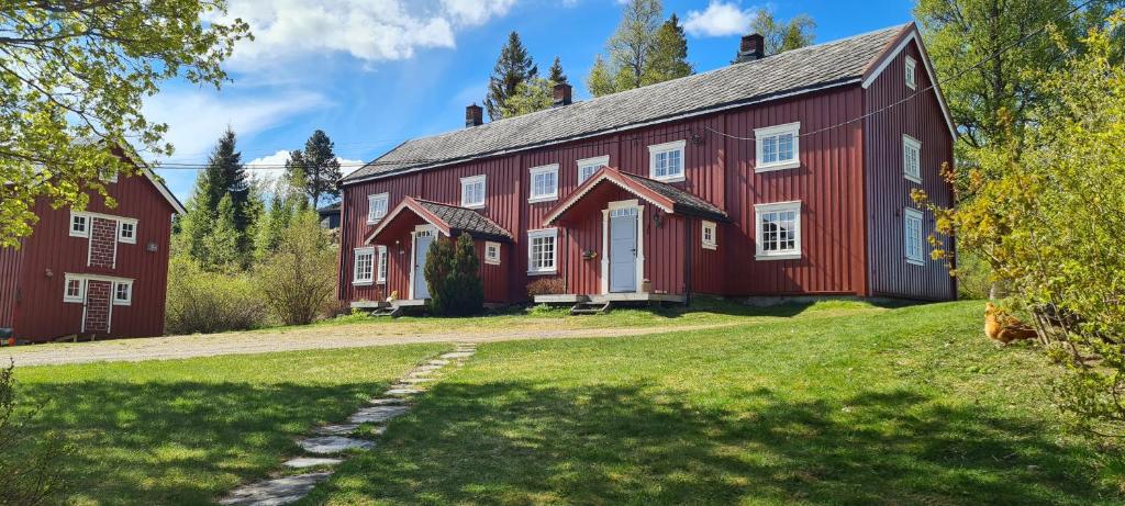 an old red barn on a grassy field at Lægran Gård in Steinkjer
