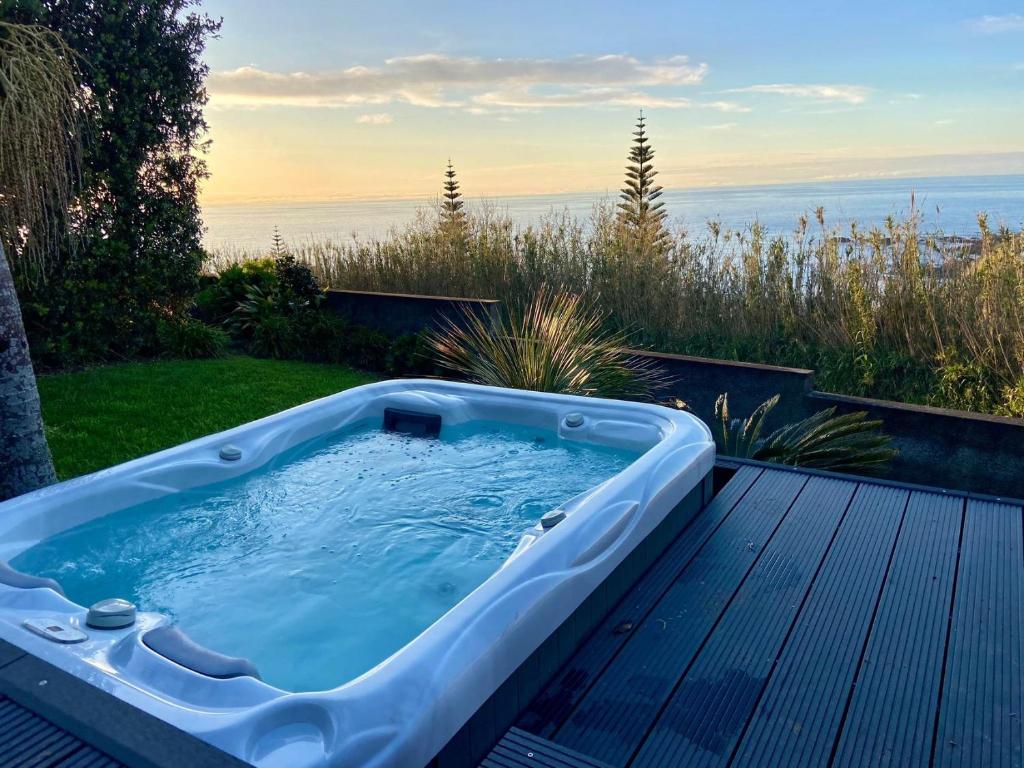 a jacuzzi tub sitting on top of a deck at GuestReady - Casa do Horizonte in Mosteiros