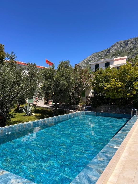 a large swimming pool with blue water in front of a building at Boutique Home Saltaragazza in Petrovac na Moru