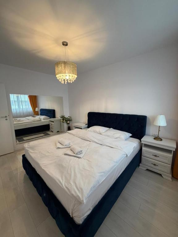 a large bed in a bedroom with a chandelier at Elite Noua in Braşov