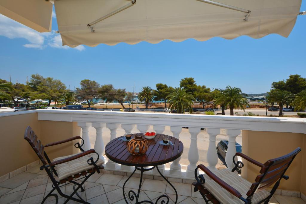 a table and chairs on a balcony with a view at Vista Mare I in Porto Heli