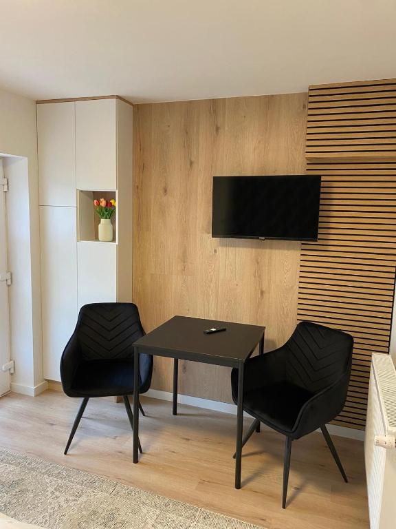 a dining room with a table and two black chairs at Natalia 2 in Mrągowo