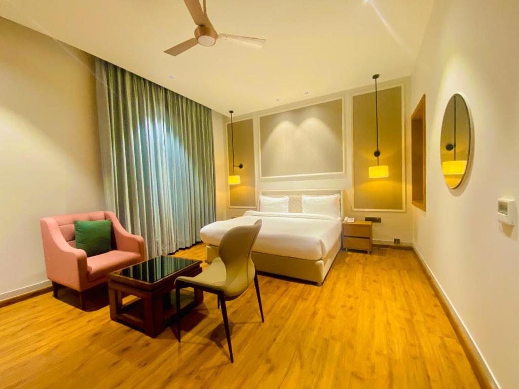 a hotel room with a bed and a chair at Royal palm hotel and resort in Niāl
