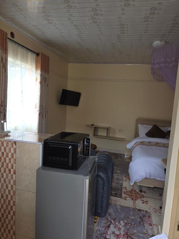 a kitchen with a microwave on top of a refrigerator at Rosemond cottages eldoret in Eldoret