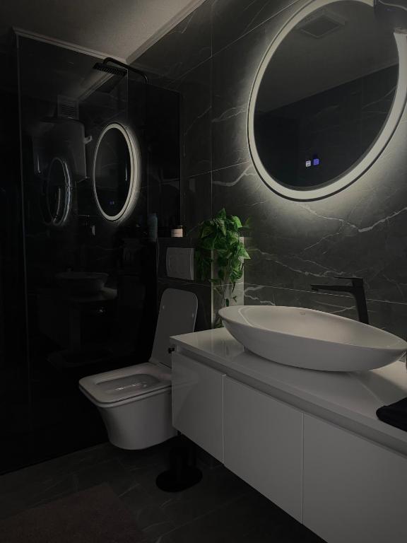 a bathroom with a sink and a toilet and a mirror at AD PRESTIGE Apartment in Gradačac