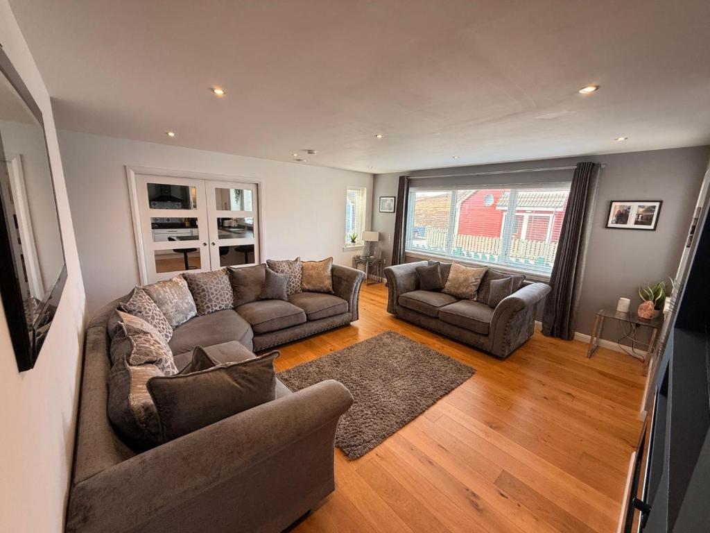 a living room with two couches and a large window at 6 Pegasus Place in Lerwick