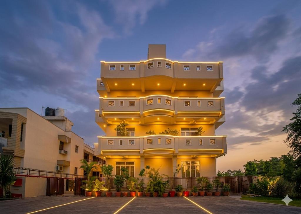 a large yellow building with a sunset in the background at R41 - Boutique Hotel Vaishali Nagar Jaipur in Jaipur