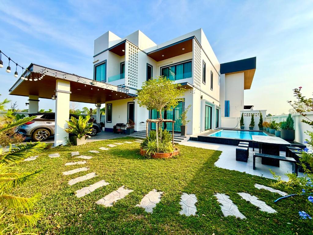 a house with a garden in front of it at Bonus Pool Villa Chiang Mai in Chiang Mai
