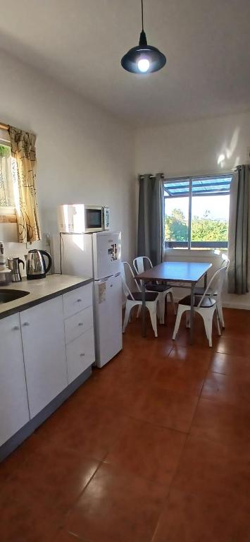 a kitchen with a table and a table and chairs at Piedra de Luna o Sur in Villa Serrana