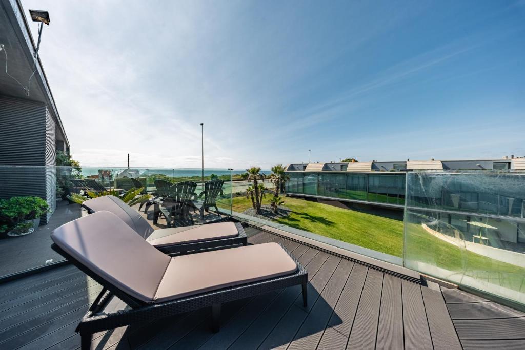 a balcony with chairs and a view of the ocean at Pedrinhas Village by Geyra in Esposende