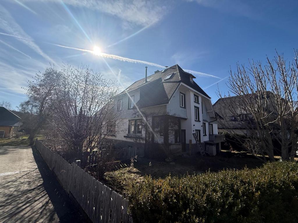 a large white house with the sun in the sky at berg zeit in Hinterzarten in Hinterzarten