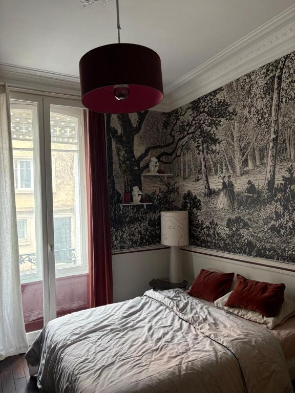 a bedroom with a bed with a painting on the wall at Appartement centre rennes in Rennes