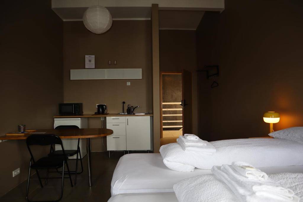 a room with two beds and a table and a kitchen at Blue Viking Studios in Keflavík