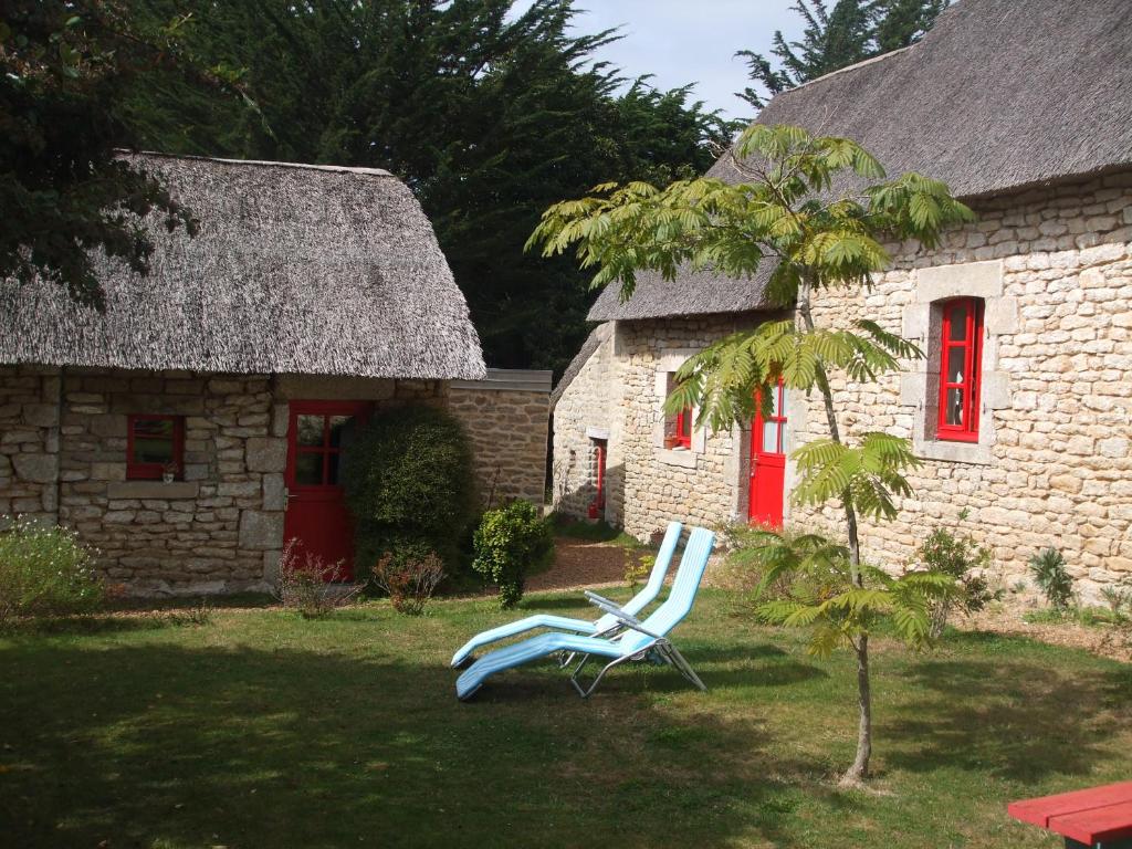 une chaise assise devant une maison en pierre dans l'établissement La Sirène Endormie, à Penmarcʼh