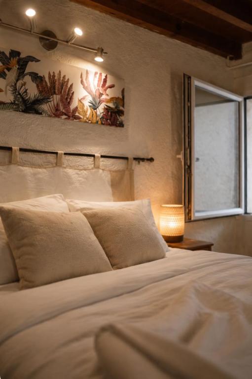 a bedroom with a white bed with a window at Maisonnette avec piscine - sud Ardèche in Saint-Montan