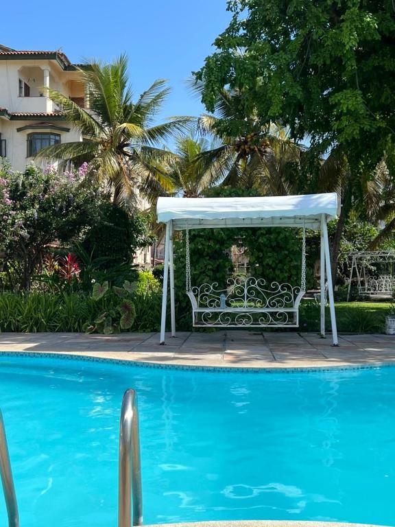 a white gazebo sitting next to a swimming pool at TULIVU Homes in Mombasa