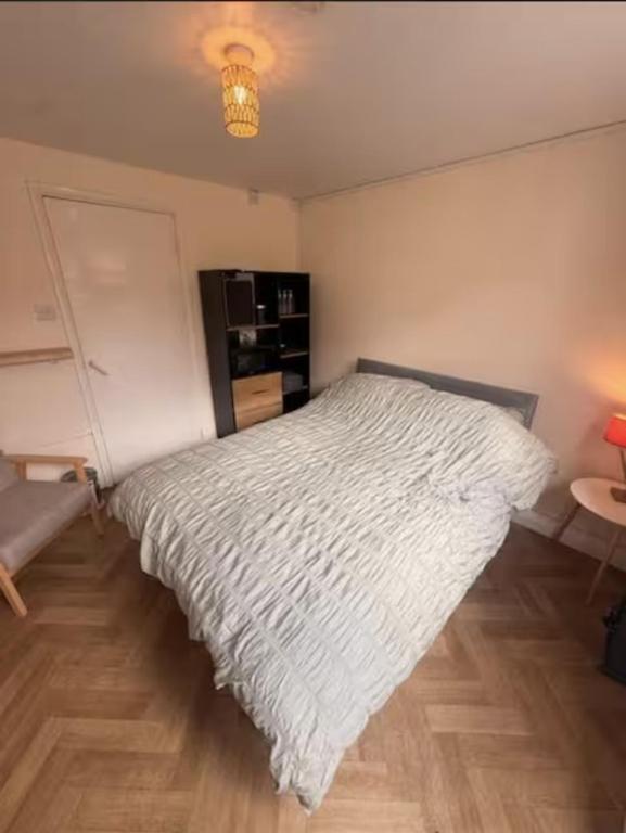 a bedroom with a bed with a white comforter at The Burrow at Black Rabbit Pub in Haybridge