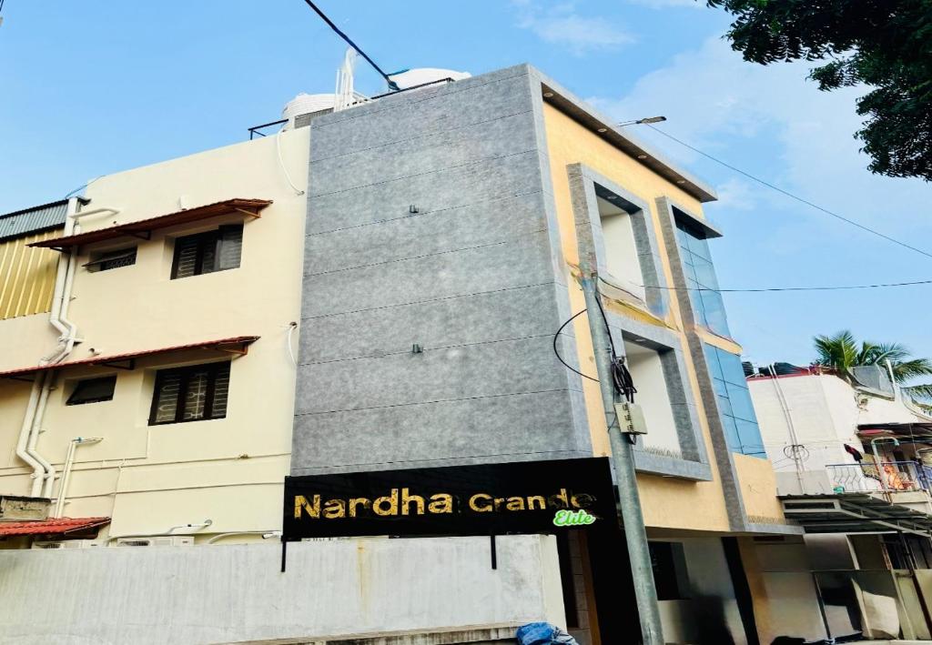a building with a sign on the side of it at Nandha Grande Elite in Udumalaippettai