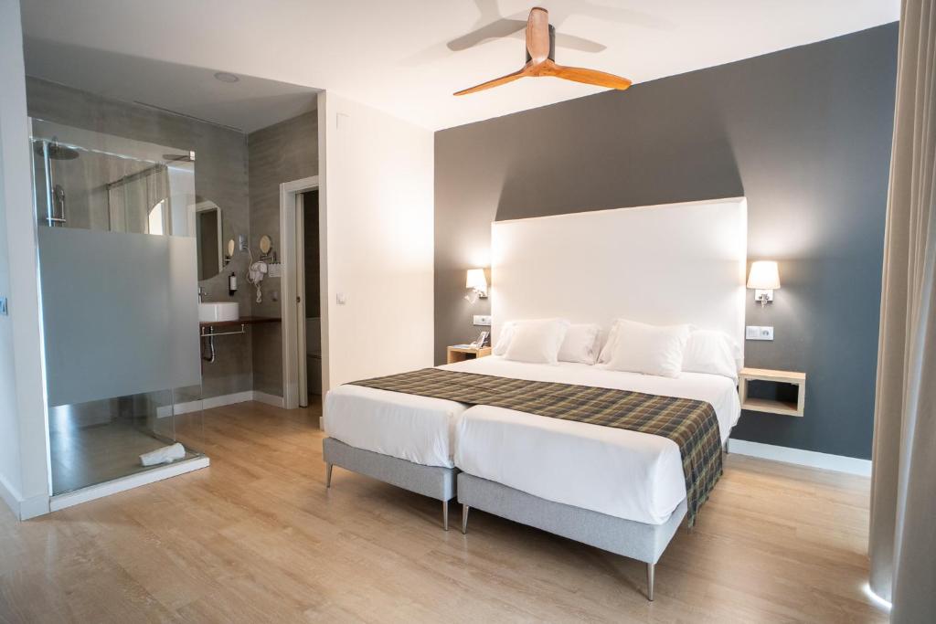 a bedroom with a bed and a flat screen tv at Añoreta Suites in Rincón de la Victoria